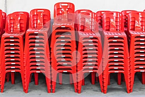 Stacked red plastic chairs in rows