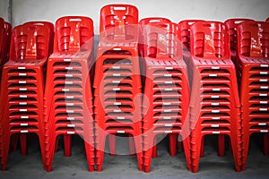 Stacked red plastic chairs in rows
