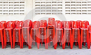 Stacked red plastic chairs in rows