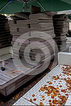 Stacked seat cushions in a Munich outdoor cafe on a rainy day in autumn