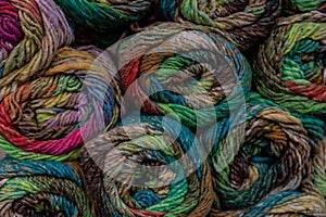 Stacked skeins of colorful rustic yarn, carded and drawn, creative copy space background for fiber crafts photo