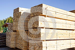 Stacked stacks of wooden planks against the sky. Lumber warehouse, wood drying.