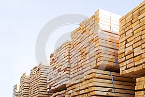 Stacked stacks of wooden planks against the sky. Lumber warehouse, wood drying.