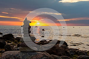 Stacked stones on a coast at orange sunset