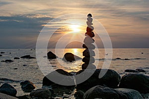 Stacked stones on a coast at orange sunset