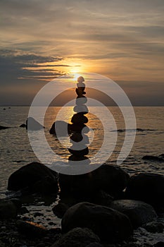 Stacked stones on a coast at orange sunset