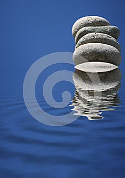 Stacked Stones Refelcting in Blue Water