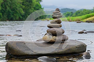Stacked stones on the river with nature background