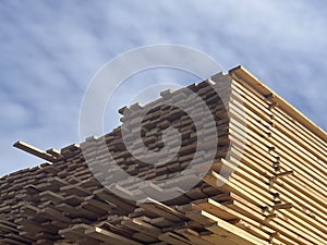 Stacked Timber Planks at a Lumberyard Awaiting Transportation. Stacked wooden planks in varying shades of brown at a