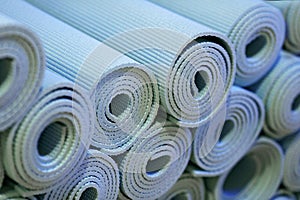 Stacked up Collection of Blue Rolled Yoga Mats at Fitness Gym