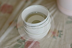 Stacked White Ceramic Bowls on Floral Tablecloth