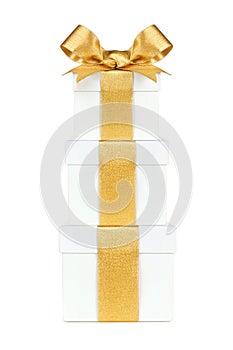 Stacked white gift boxes wrapped with gold ribbon and bow isolated on white