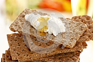 Stacked wholemeal crispbread with cream cheese and honey