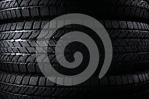 Stacked winter tires as background, closeup. Car maintenance