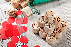 Stacked wooden lotto barrels, game cards and red chops for a game in lotto