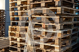 Stacked wooden pallets at a storage or near a shop.