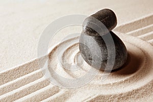 Stacked zen garden stones on sand with pattern