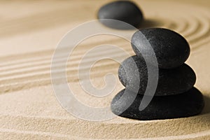 Stacked zen garden stones on sand with pattern, space for text