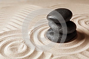 Stacked zen garden stones on sand with pattern, space for text