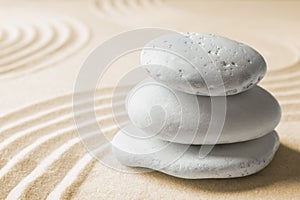 Stacked zen garden stones on sand with pattern, space for text