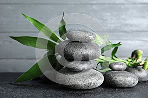 Stacked zen stones and bamboo leaves on table