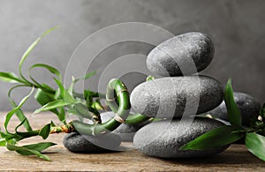 Stacked zen stones and bamboo on table against grey background.