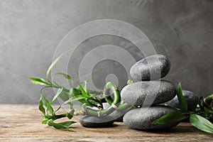 Stacked zen stones and bamboo on table against grey. Space for text