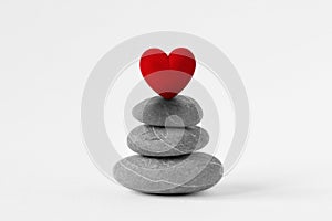 Stacked Zen stones with heart on white background - Concept of love and balance