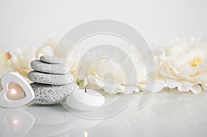 Stacked zen stones with white burning candle.