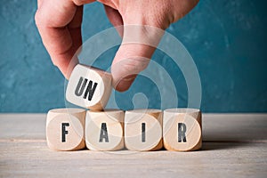Stacking blocks with letters to spell unfair photo