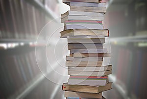 Stacking books with blur bookshelfs background in library room