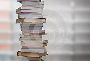 Stacking books with blur bookshelfs background in library room