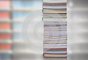 Stacking books with blur bookshelfs background in library room