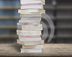 Stacking books on wood desk with blur bookshelfs background