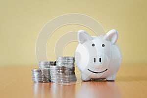 Stacking coins pile and white piggy bank for savings with money and planning step up to growing