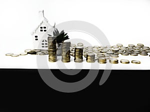 Stacking gold coins tower and house, saving money and loan for construction real estate and home concept