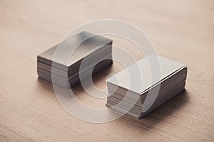 stacks of black and white empty business cards on wooden surface.