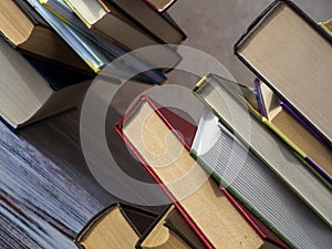 Stacks of books on the table at an angle to the background. Books lie on top of each other with an offset. Concept of