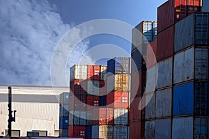 Stacks of cargo containers, import export ships in port harbour, industrial cargo shipping, container logistics, maritime