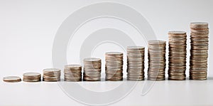 Stacks of coins in ascending order on table closeup