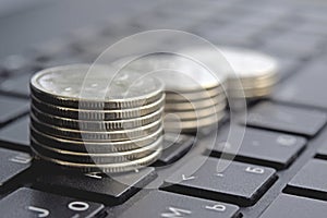 Stacks of coins on laptop keyboard