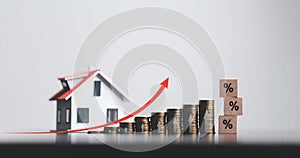 Stacks of coins and model house with percentage symbol for increasing interest rates. Interest rate financial and mortgage rates.