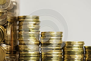 Stacks of Coins next to a jar full of coins