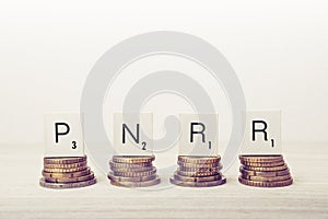 Stacks of coins with PNRR letters. UE economy concept. photo