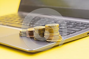 Stacks of coins reminding dgrowing diagram on computer keyboard. Business growth and expanding concept  stock market online