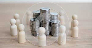 Stacks of coins surrounded by human figures