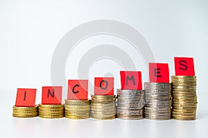 Stacks of coins and text `incomes`. Increase in revenue and earnings.