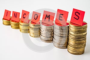 Stacks of coins and text `incomes`. Increase in revenue and earnings.