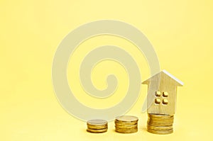 Stacks of coins and a wooden house. The concept of saving money for buying a home. Buy an apartment, real estate. Payment of rent