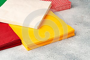 Stacks of colorful paper napkins on gray background